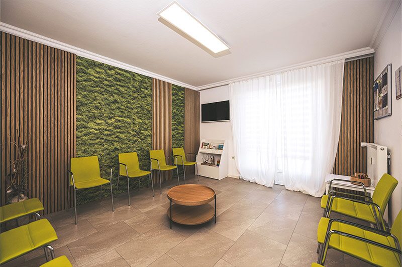 Wartezimmer mit Moosbild und Sitzgelegenheiten